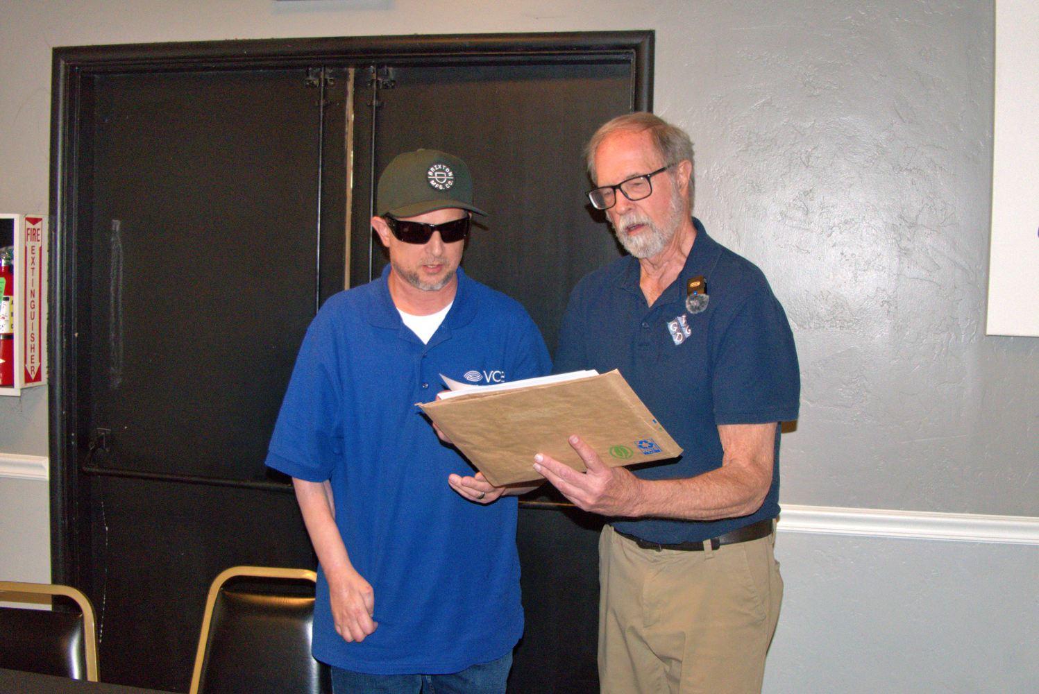 Lion President tom presents Lion Alvin with his new member paperwork., 